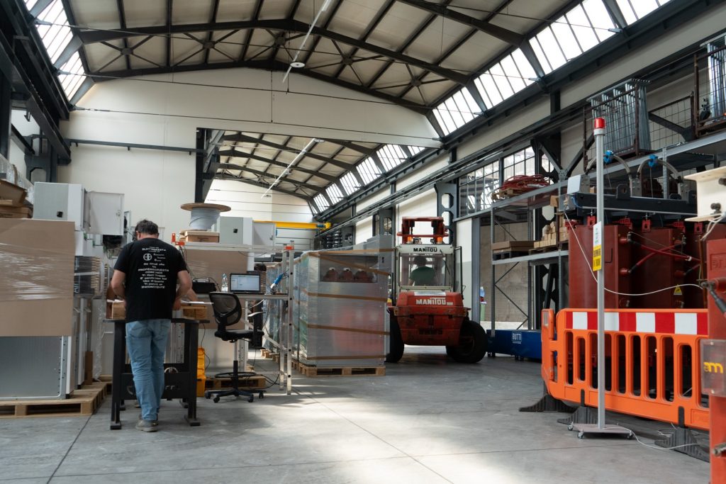 Tecnici Eurotrafo al lavoro nell'officina con carrello elevatore e quadri elettrici